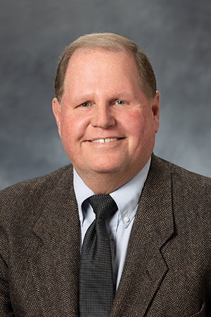 Brian Napstad in a brown suit, black tie and white shirt