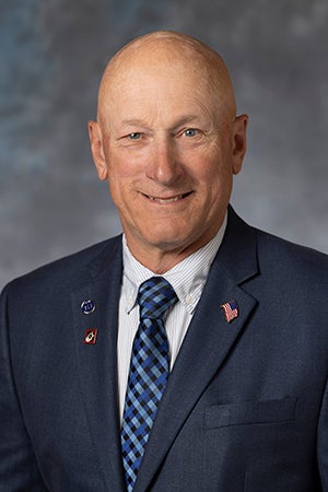 Dan Kingsley in blue suit, white shirt and blue tie