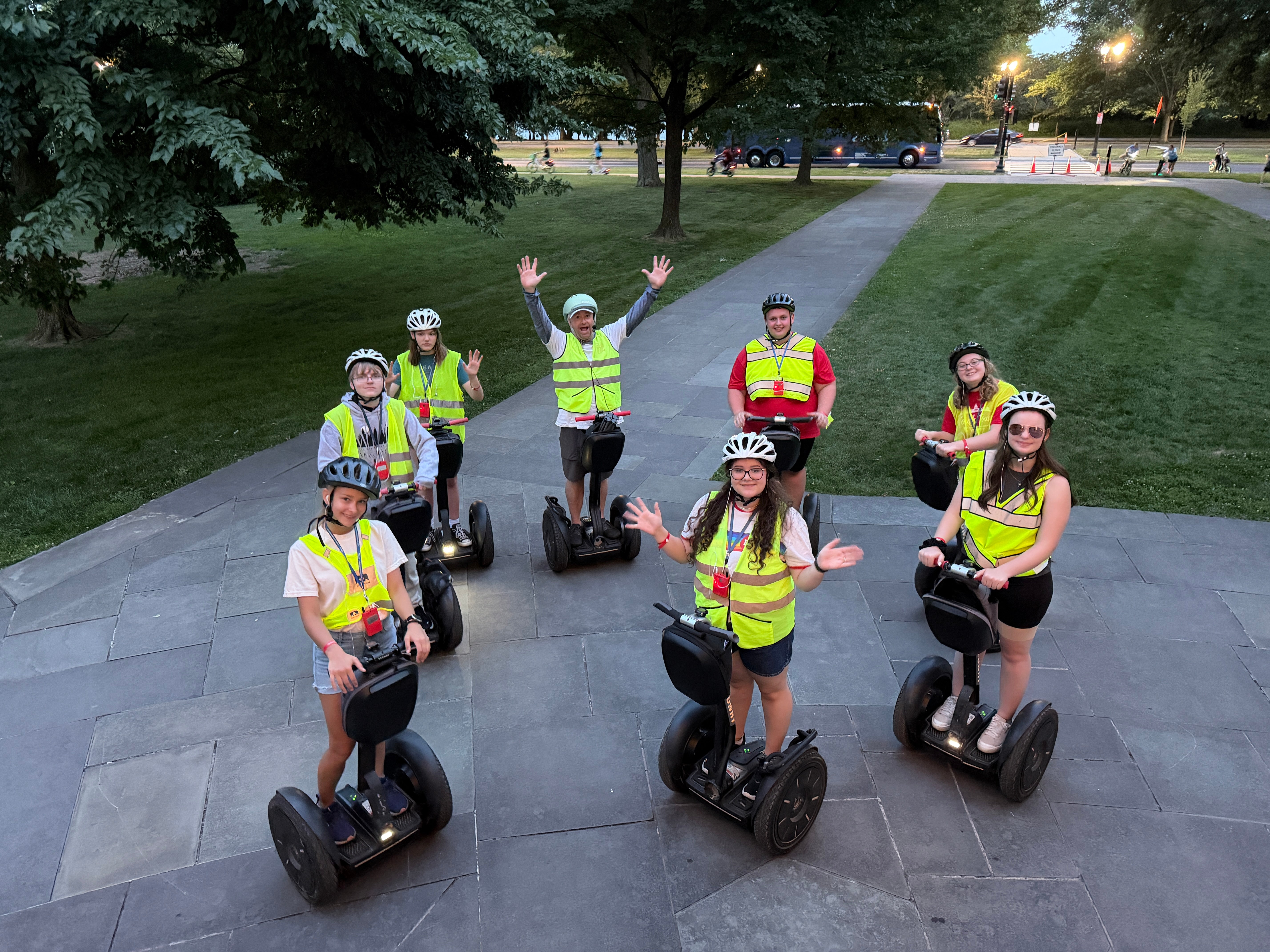 people in yellow vests riding on segways