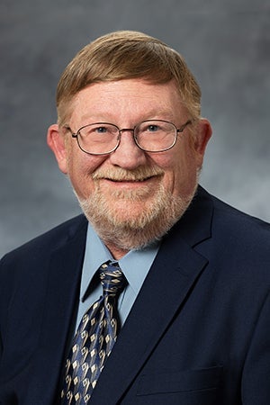 Jeff Sheldon in a blue shirt/tie and black jacket