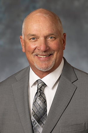 Larry Anderson in gray suit and tie, white shirt
