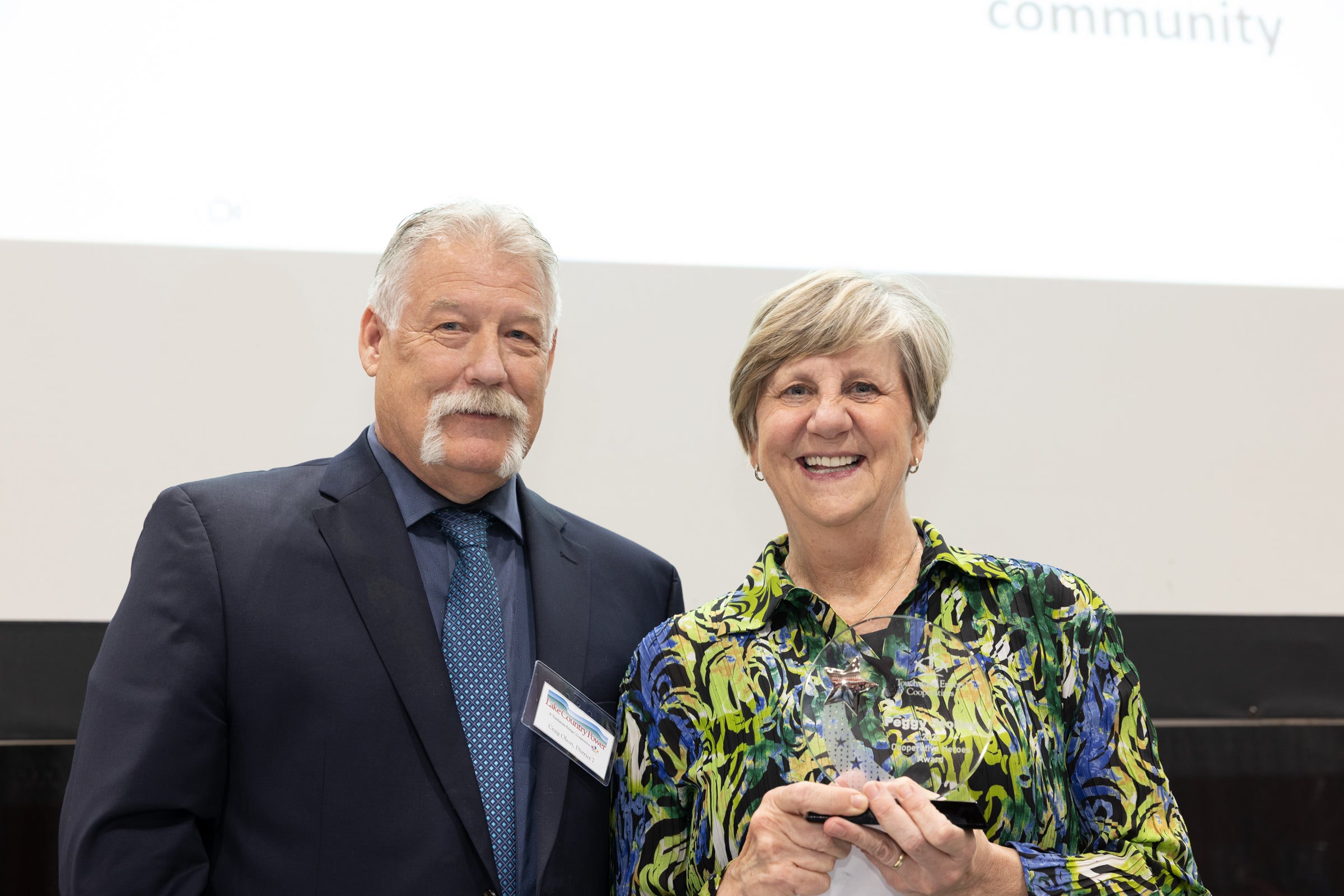 man and a woman posing with an award