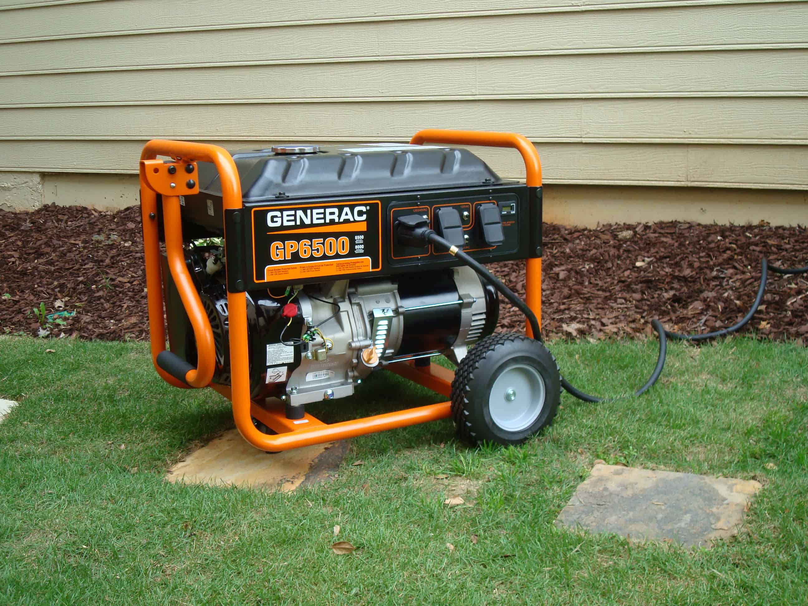 orange and black portable generator outside a house